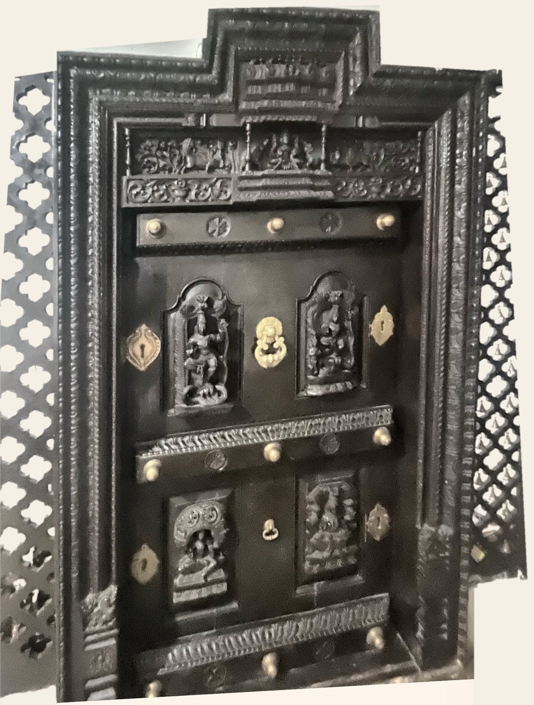 Antique carved teak door with arched deity panels, brass knobs and pierced jaali side panels
