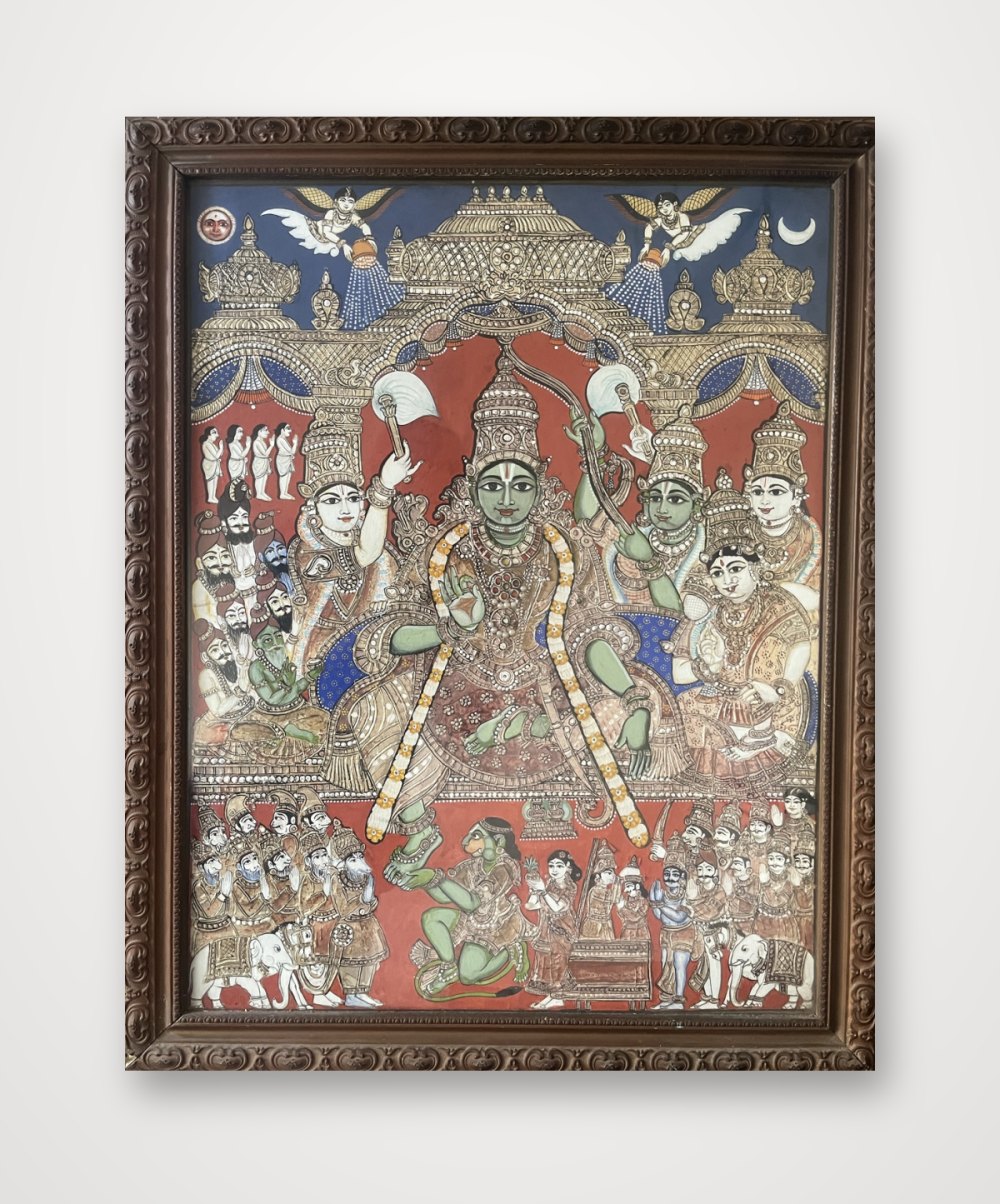 Painting of the coronation of Rama with Sita, his brothers and Hanuman, in a carved wooden frame on a white wall
